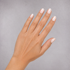 Hand with light pink nail polish on a gray background