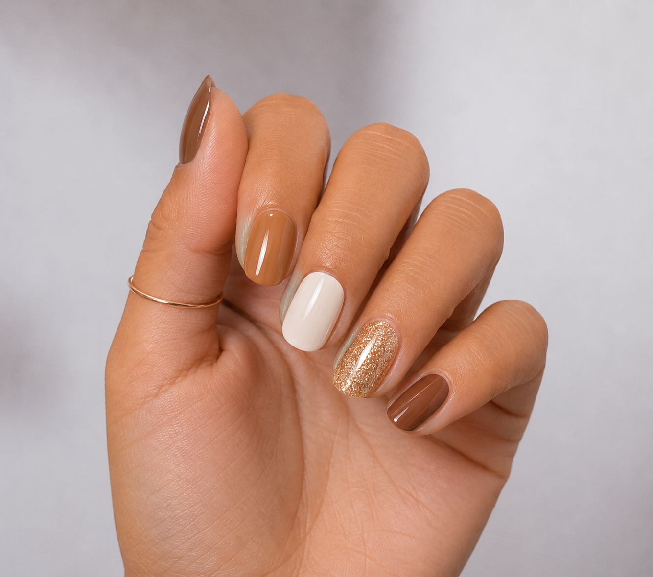 יד עם מדבקות ג׳ל Truffle Glow בגווני טראפל, קרמל, שמנת ונצנצי שמפניה מבית Lakshē